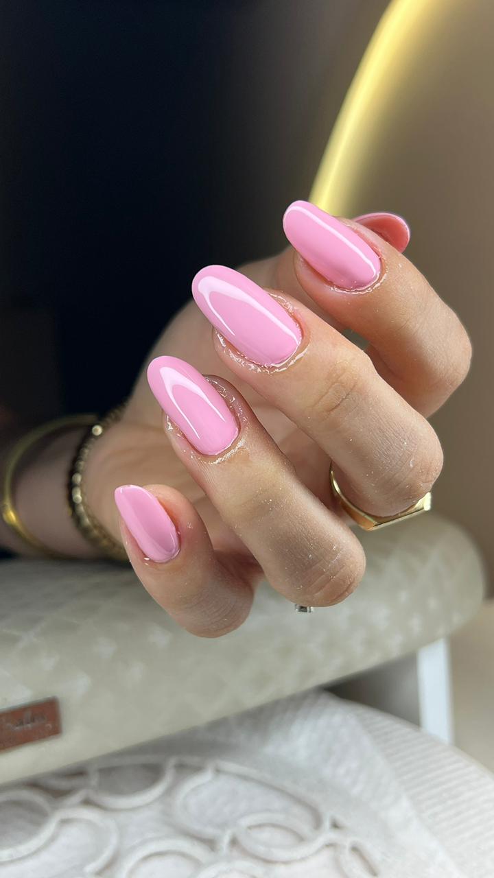 "Unhas alongadas rosa brilhante com contorno claro e acabamento uniforme em formato amendoado.