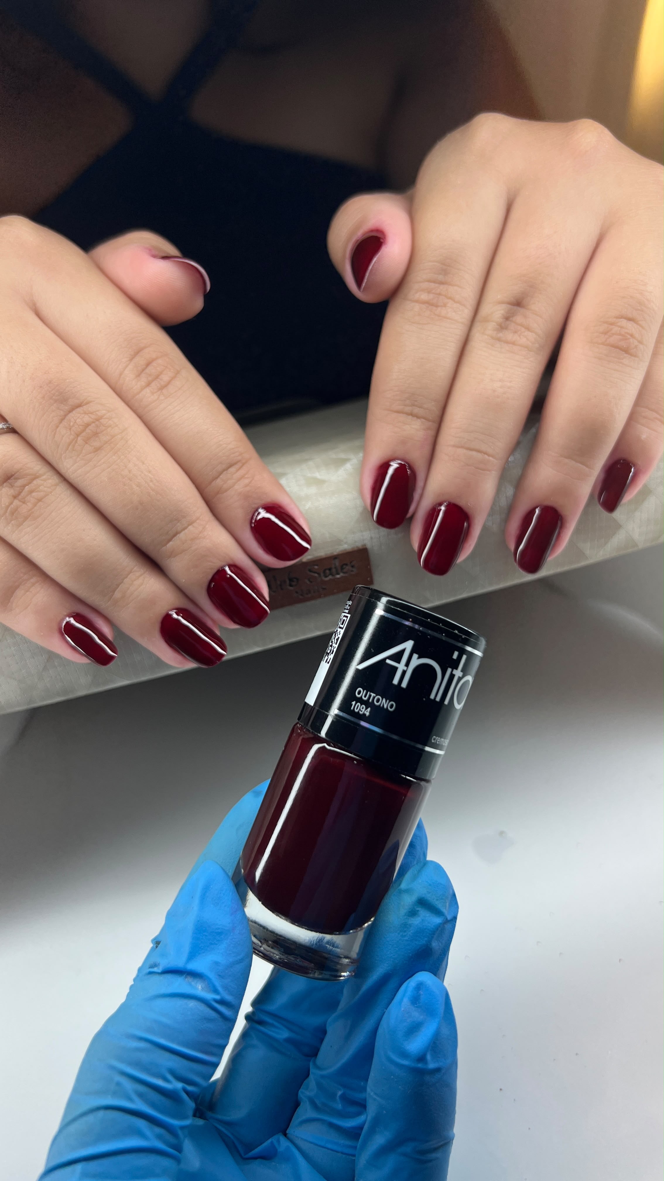 Unhas alongadas vinho escuro com acabamento brilhante e formato amendoado.